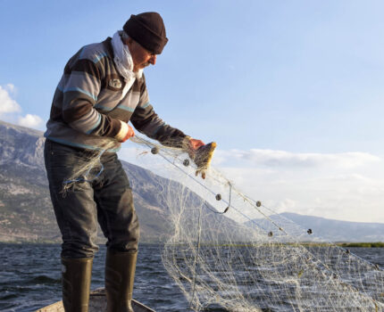 A fisher standing holding fishing net